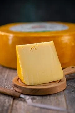 Medium hard cheese head edam gouda parmesan on wooden board with knife wooden Foto stock