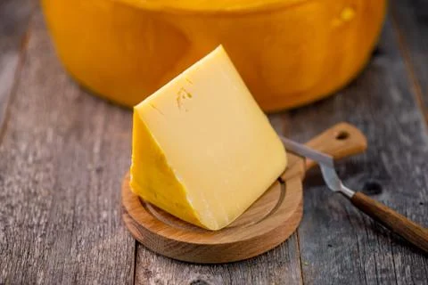 Medium hard cheese head edam gouda parmesan on wooden board with knife wooden Foto stock