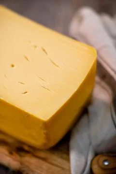 Medium hard cheese head edam gouda parmesan on wooden board with knife wooden Foto stock