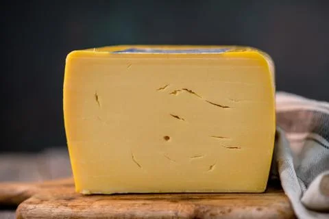 Medium hard cheese head edam gouda parmesan on wooden board with knife wooden Foto stock
