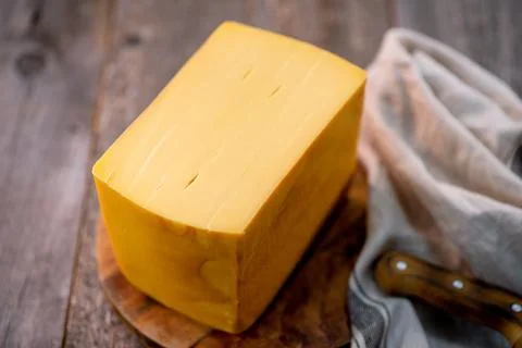 Medium hard cheese head edam gouda parmesan on wooden board with knife wooden Foto stock