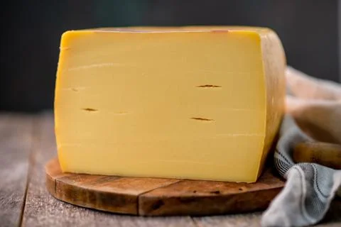 Medium hard cheese head edam gouda parmesan on wooden board with knife wooden Stock Photos