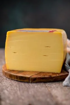 Medium hard cheese head edam gouda parmesan on wooden board with knife wooden Stock-Fotos