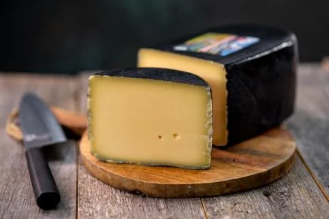 Medium hard cheese head gouda edam on wooden board with knife wooden texture 스톡 사진