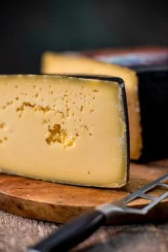 Medium hard cheese head gouda edam on wooden board with knife wooden texture Foto stock