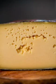 Medium hard cheese head gouda edam on wooden board with knife wooden texture Foto stock