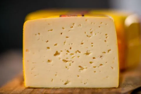 Medium hard cheese head gouda edam on wooden board with knife wooden texture Foto stock