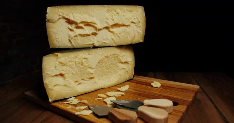 Medium hard cheese head parmesan on wooden board, with cheese parmesan knifes Video stock 146784402