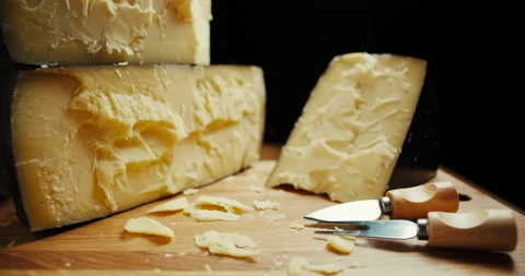 Medium hard cheese head parmesan on wooden board, with cheese parmesan knifes Video stock 146839944