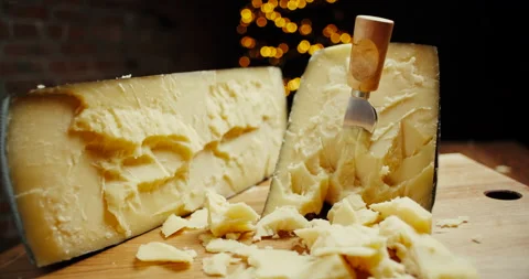 Medium hard cheese head parmesan on wooden board, with cheese parmesan knifes Video stock 146986343