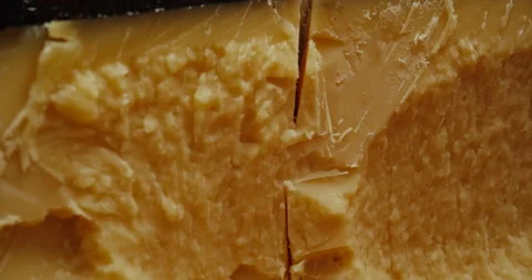 Medium hard cheese head parmesan on wooden board, rotaiting shot. Stock Footage 147221776