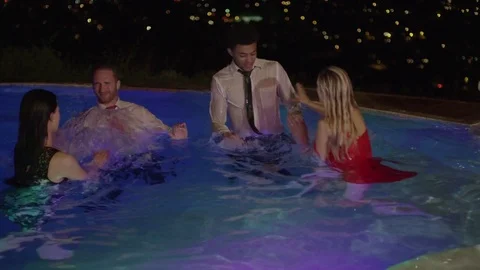 Medium high angle shot of well-dressed people splashing in pool / Cedar Hills Stock Footage 71837971