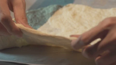 Medium high close up a man carefully streching a bread pizza base Stock Footage 127976560