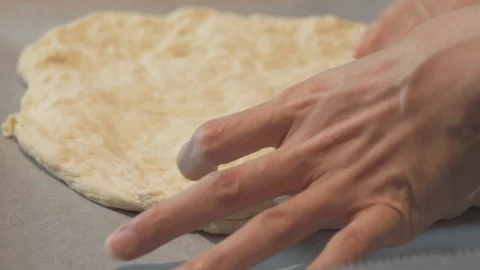 Medium high close up man covering a bread hole and carefully shape a pizza bread Stock Footage 127975716