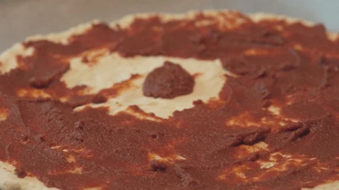 Medium high close up starting to spread a tomato paset for pizza sauce topping Stock Footage 127978577