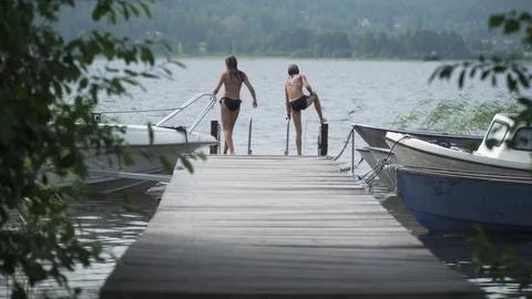 Medium, kids jumping off a deck into a lake in Sweden Stock Footage 114995178