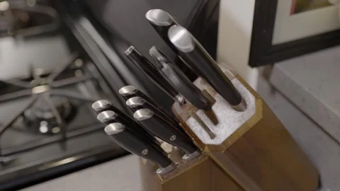 Medium kitchen knife being pulled out from a knife block and then put back in Stock Footage 315220720