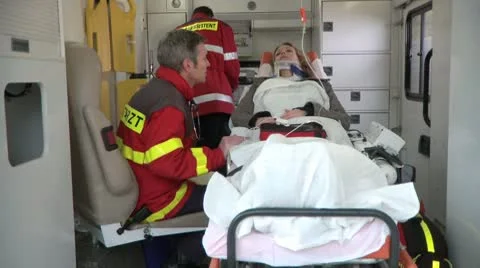 Medium lockdown shot of two paramedics attending to a patient lying on a Stock-Footage 10701375