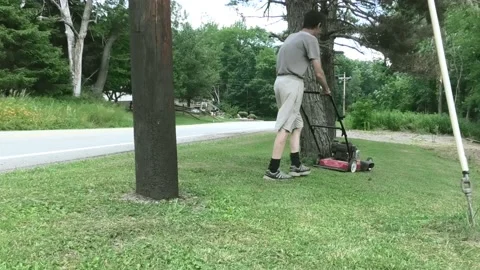 A Medium Long Shot of a Middle Aged Make Mowing Grass Stock-Footage 157375210