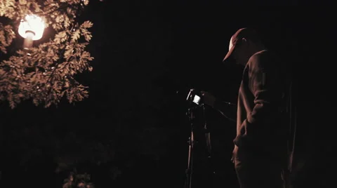Medium low angle shot of photographer using camera at night Stock Footage 60268693