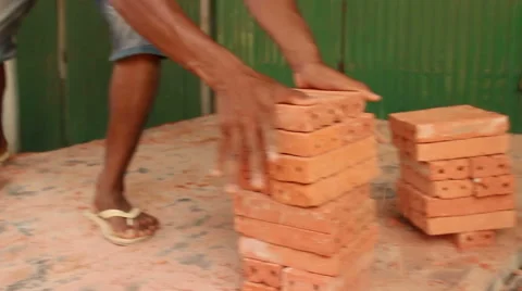 Medium low angle shot of workers unloading and stacking bricks Stock Footage 56603982