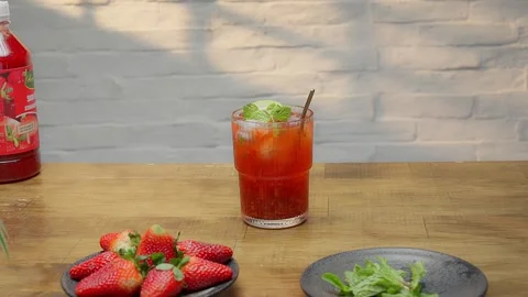 Medium pan of fresh red strawberry soda glass on blurred background 스톡 동영상 343629467
