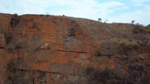 Medium pan shot of dry cliff face with red rocks in Mpumalanga South Africa Video stock 78584743