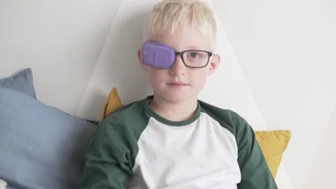 Medium plan Beautiful boy blond removes glasses with an occluder from the face Stock Footage 132536755
