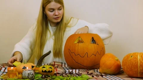 Medium plan. The girl prepares a pumpkin for halloween. Stock Footage 219258564