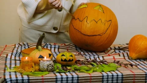 Medium plan. The girl prepares a pumpkin for Halloween. 4K. Stock Footage 219259822
