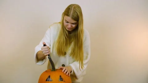 Medium plan. The girl is preparing a pumpkin for the holiday. Halloween Stock Footage 219255907