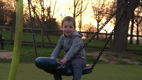 Medium plan Portrait of cute little boy having fun Swinging On Swing outside Stock Footage 172507755