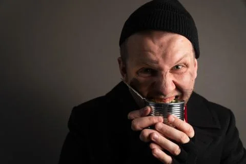 Medium plan young homeless man rejoices in a tin can. Unemployed beggar concept Stock Photos