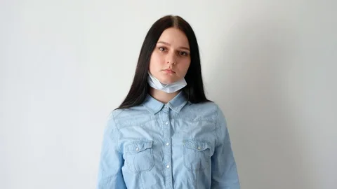 Medium plan young serious woman long hair wearing medical mask looking Stock Footage 128756433