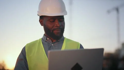 Medium portrait of high-skilled engineer with laptop at construction site Stock Footage 318343274