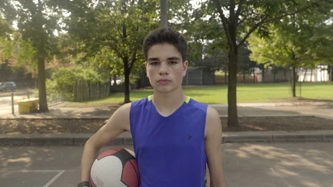 Medium push in shot of a young man standing with a basketball in hand. Stock Footage 80342139