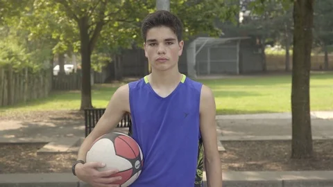 Medium push in shot of a young man standing with a basketball in hand. Stock Footage 80342302