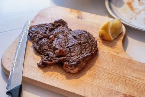 Medium rare Beef grilled with lemon slice on wood chopping block Stock Photos
