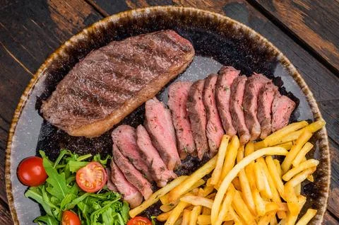 Medium rare beef rump cap or top sirloin cap steak served with crispy fries.. Stock Photos