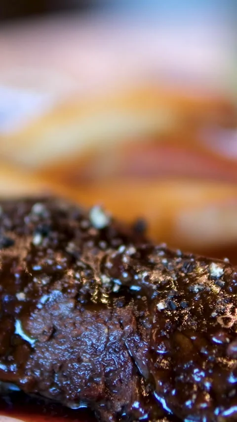Medium rare beef steak is complemented by barbeque sauce, a fresh salad, and a Vídeo Stock 293022546
