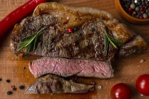 Medium Rare meat cut for piece of ribeye beef meat on wooden cutting board on Foto stock