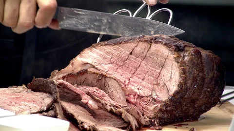 Medium rare prime rib roast with multiple slices being carved Stock Footage 102136867