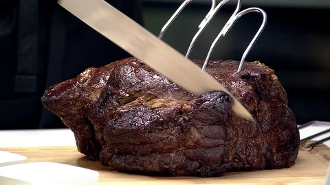 Medium rare prime rib roast being sliced Stock Footage 102136942