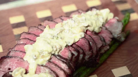 Medium rare roasted beef tenderloin sliced on wooden board with salt and pepper Stock-Footage 132101363
