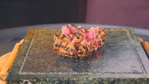 Medium rare steak on a hot stone in flame Stock Footage 73255741