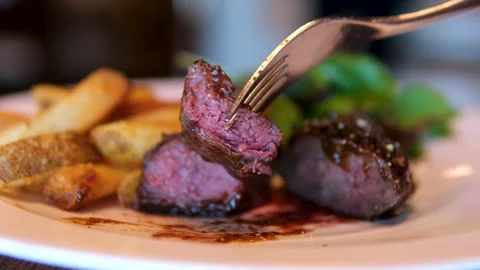 Medium rare steak plate with roasted tomato, garlic, and fresh herbs Stock Footage 295058288