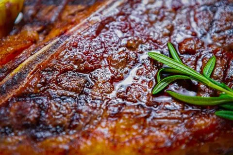 Medium rare t-bone steak cooked on grill in restaurant,served with fresh rose Stock Photos