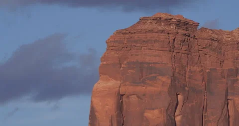 Medium of a red rocky butte with the clouds behind it in Monument Valley Vídeos de archivo 303410496