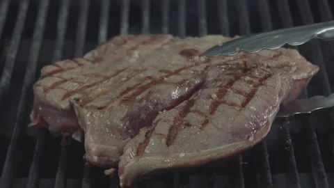 Medium roast steak is turning over on the grill Stock Footage 80803496