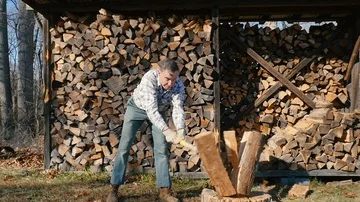 Medium Scene of an Active Senior Man Chopping Firewood in Slow Motion Stock Footage 85643103